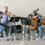Giving an outdoor concert at Dry Creek Elementary School in Port Angeles are, from left, Noah Geller, James Garlick, Efe Baltacigil and David Auerbach. The musicians came from Seattle, Minnesota and Port Angeles. (Keith Thorpe/Peninsula Daily News)