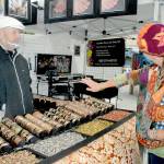 Saffrel Cochon of Monroe, right, tries on a bracelet as vendor Larry Rankin of Leavenworth-based Art to Suit You looks on at the Juan de Fuca Festival street fair outside the Vern Burton Community Center in Port Angeles. (Keith Thorpe/Peninsula Daily News)