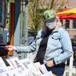 Bonnie Romani of Ocean Shores admires Mike Biskup's outdoor art gallery in downtown Port Townsend. Biskup and his work appear each weekend at the foot of Water Street.   Diane Urbani de la Paz/Peninsula Daily News