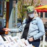 Bonnie Romani of Ocean Shores admires Mike Biskups outdoor art gallery in downtown Port Townsend. Biskup and his work appear each weekend at the foot of Water Street. (Diane Urbani de la Paz/Peninsula Daily News )