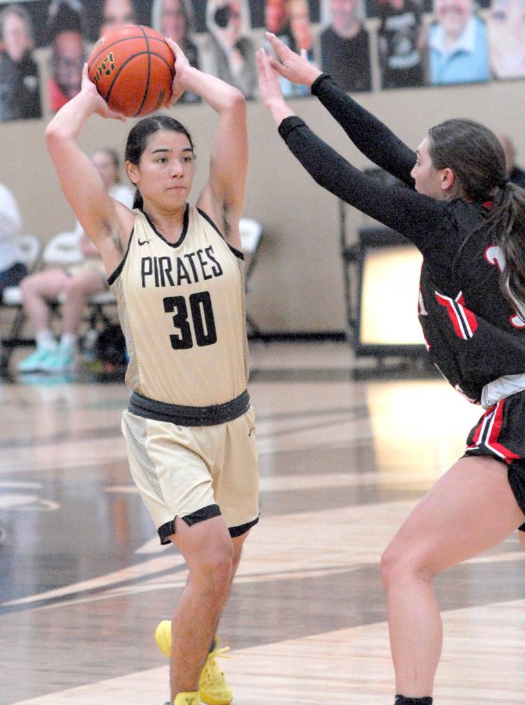 Keith Thorpe/Peninsula Daily News Peninsulas Tayvia Cabatbat, left, looks to pass while defended by Olympics Esther Pappuleas on Saturday at Peninsula College in Port Angeles.