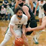 Keith Thorpe/Peninsula Daily News Port Angeles Jeremiah Hall, front, slips past North Kitsaps Jack Ryan on Thursday night in Port Angeles.