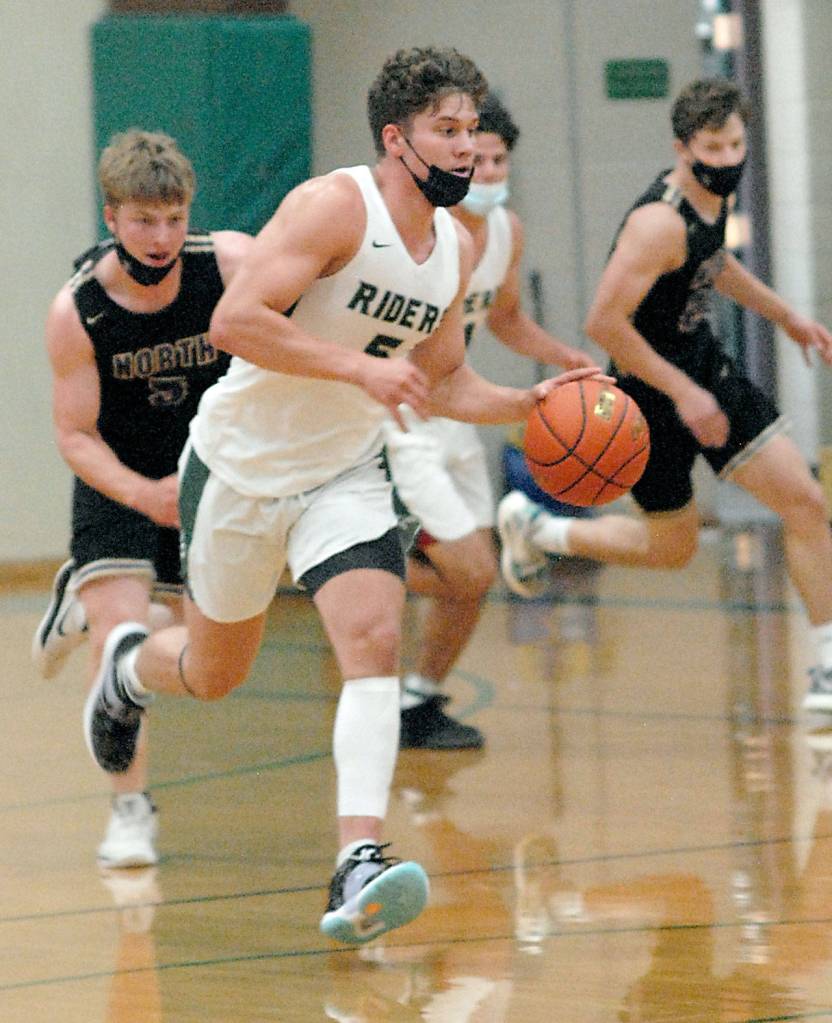 Keith Thorpe/Peninsula Daily News Port Angeles Chase Cobb drives down court pursued by North Kitsaps Colton Bower, left, and Jack Ryan, right, and teammate Jeremiah Hall on Thursday at Port Angeles High School.