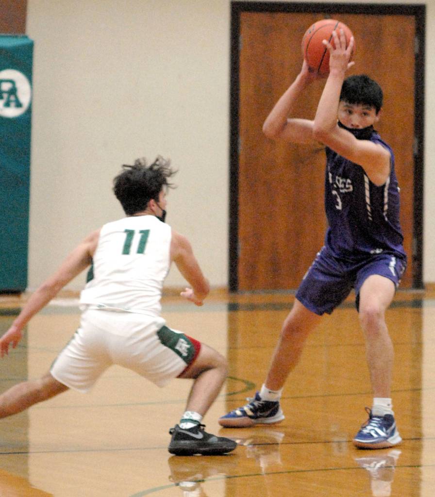Keith Thorpe/Peninsula Daily News Sequims Isaiah Moore, right, looks to pass as Port Angeles Xander Maestas closes in on Saturday in Port Angeles.