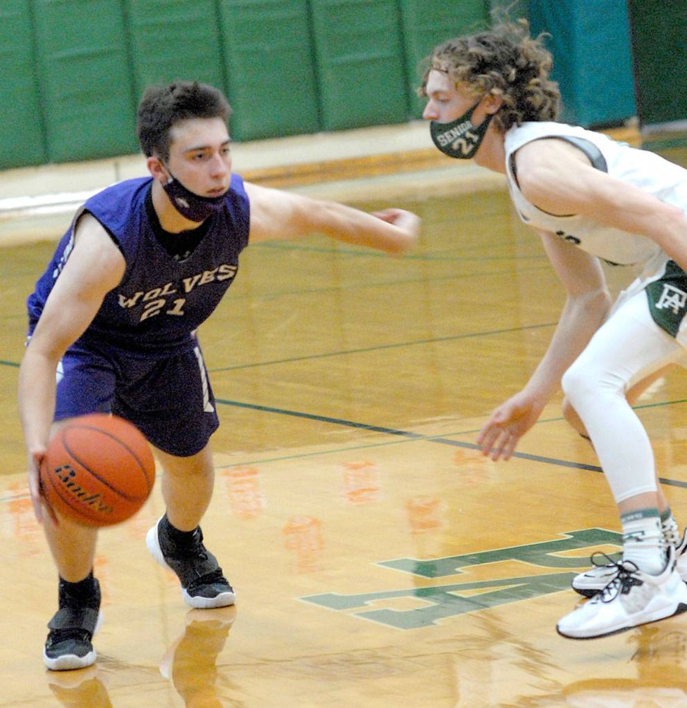 Keith Thorpe/Peninsula Daily News Sequims Jayden Possin, left, looks for a way around Port Angeles Dru Clark on Saturday night in Port Angeles.