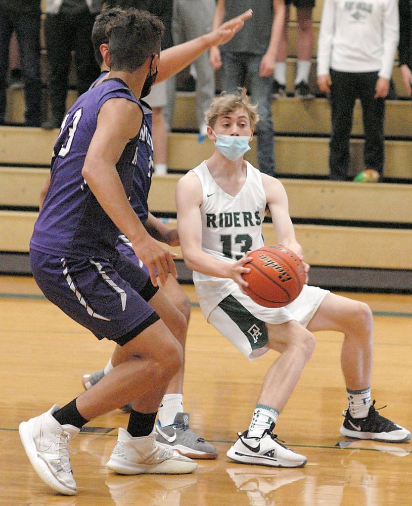 Keith Thorpe/Peninsula Daily News Port Angeles Tanner Price holds short of the lane as the defense of Sequims Hayden Eaton, front, and Pryce Glasses closes in on Saturday at Port Angeles High School.