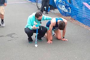Adam Klein of Tualatin, Ore., collapses after winning the North Olympic Peninsula Marathon. (Pierre LaBossiere/Peninsula Daily News)