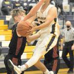 (Lonnie Archibald/for Peninsula Daily News) Forks Tony Hernandez-Flores drives towards the basket past Rainiers Logan Bowers during this district play-off Monday game in Forks. The Spartans lost 61-56 to the Mountaineers.