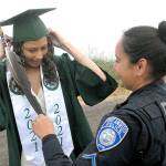 Port Angeles High School graduate Kayanna Cordero gets assistance with her mortarboard from her mother, Port Angeles police Resource Officer Swift Sanchez, prior to the start of Fridays Senior Parade from Ediz Hook to the area of Port Angeles High School. (Keith Thorpe/Peninsula Daily News)