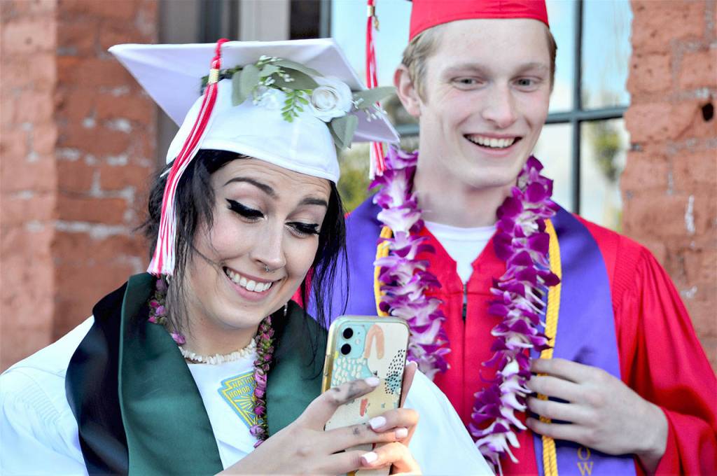 The best thing about graduation is getting to be with my class, after so long, said Cedar Elliott, left. The 18-year-old joined classmate Yarrow Dean, 17, to walk to Memorial Field for the graduation ceremony Friday night. (Diane Urbani de la Paz/Peninsula Daily News)