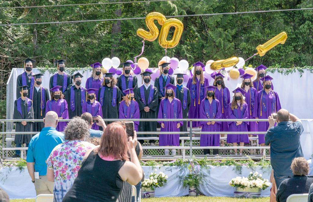 Parents and friend take photos of the 2021 graduating class of Quilcene High School during a ceremony on Saturday at the high school. (Steve Mullensky/for Peninsula Daily News)