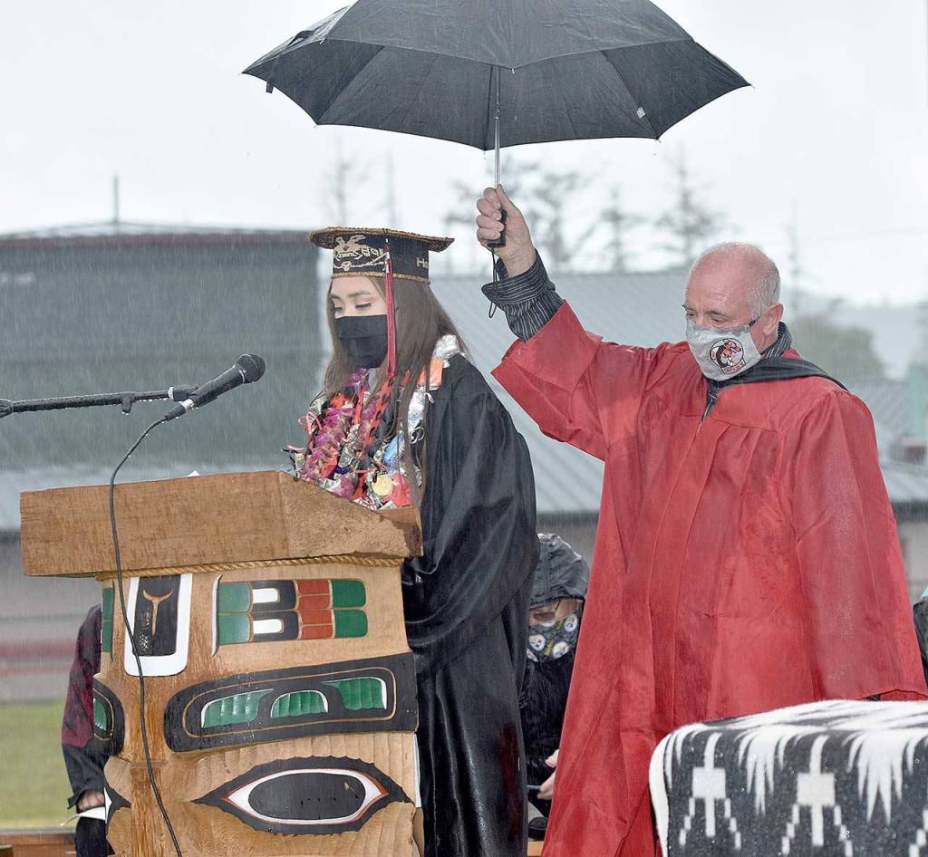 Shilaily Woodruff provides the Salutatorians Address as William Monette holds an umbrella to protect her from the rain during Neah Bay High Schools graduation ceremony on Friday. (Photo courtesy of Maria Tolliver)