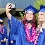 Tia Berson, left, and Chloe Mandeville take a selfie just before their march onto the field at Crescent High School for graduation ceremonies Saturday afternoon. There were 12 members of Crescent's Class of 2021: Katelyn Baar, Brendan Bergstrom, Tia Berson, James Bruch, Ashley Girard, Lael Harris, Justin Irving, Zach Irving, Darren Lee, Chloe Mandeville, Wyatt Mattix and Colton O’Neel. There was no designated valedictorian this year. (Dave Logan/for Peninsula Daily News)