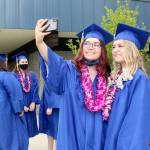 Tia Berson, left, and Chloe Mandeville take a selfie just before their march onto the field at Crescent High School for graduation ceremonies Saturday afternoon. There were 12 members of Crescents Class of 2021: Katelyn Baar, Brendan Bergstrom, Berson, James Bruch, Ashley Girard, Lael Harris, Justin Irving, Zach Irving, Darren Lee, Mandeville, Wyatt Mattix and Colton ONeel. There was no designated valedictorian this year. (Dave Logan/for Peninsula Daily News)