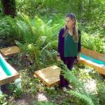 Port Angeles Fine Arts Center executive director Christine Loewe admires an art installation, The Pool Zone by Chris Oliver, debuting Saturday in the Websters Woods Sculpture Park. (Keith Thorpe/Peninsula Daily News)
