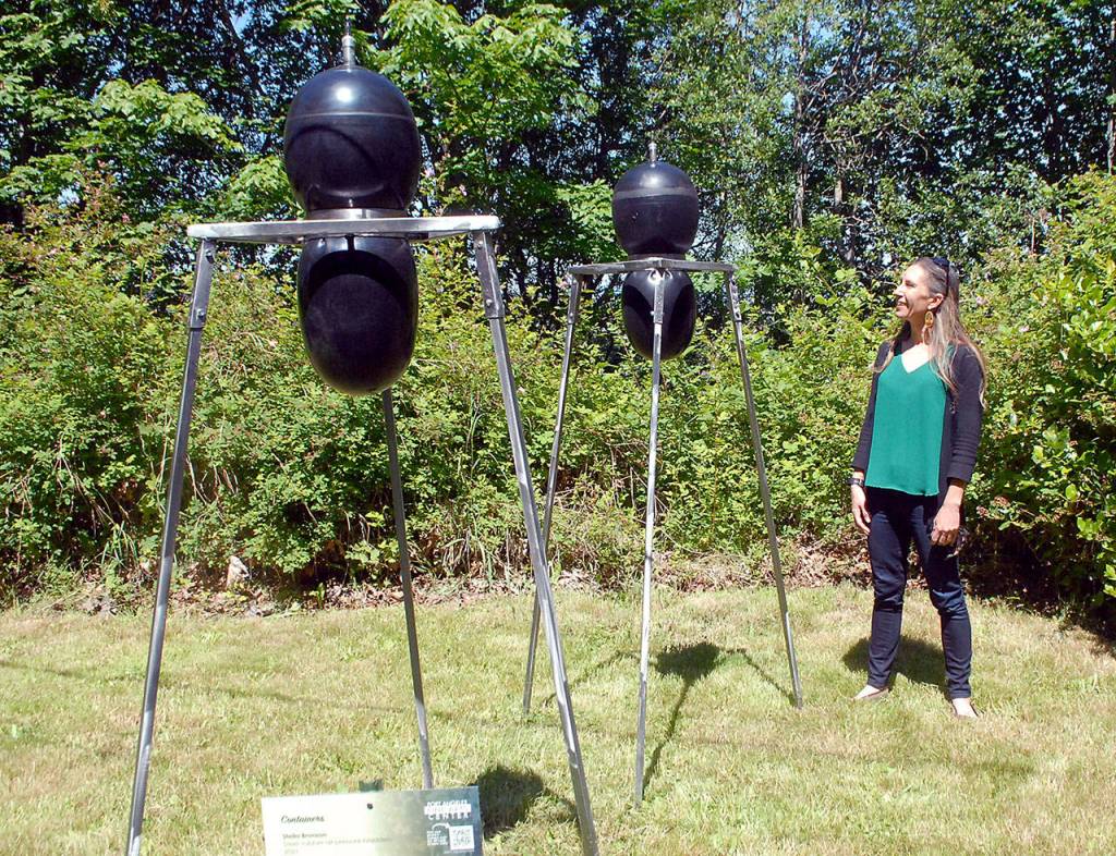Christine Loewe examines a new art installation, Containers by Stella Bronson, outside the Port Angeles Fine Arts Center. The work is among the new pieces in the Summertide Solstice Art Festival this Saturday. (Keith Thorpe/Peninsula Daily News)