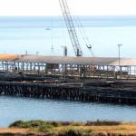 Keith Thorpe/Peninsula Daily News
Crews work on Thursday to dismantle the loading dock at the site of the former Rayonier pulp mill in Port Angeles. Workers began removing about 800 concrete dock panels this week as a step toward dismantling the 6-acre pier at the former Rayonier property 2 miles east of downtown Port Angeles. The target date for completion is July, while more than 5,000 creosote-treated pilings will not be taken out at least until 2023 as part of the overall environmental cleanup of the 75-acre former industrial site's uplands and adjacent harbor waters, a process overseen by the state Department of Ecology and paid for by property owner Rayonier Advanced Materials.