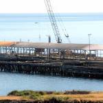 Crews work on Thursday to dismantle the loading dock at the site of the former Rayonier pulp mill in Port Angeles. Workers began removing about 800 concrete dock panels this week as a step toward dismantling the 6-acre pier at the former Rayonier property 2 miles east of downtown Port Angeles. The target date for completion is July, while more than 5,000 creosote-treated pilings will not be taken out at least until 2023 as part of the overall environmental cleanup of the 75-acre former industrial sites uplands and adjacent harbor waters, a process overseen by the state Department of Ecology and paid for by property owner Rayonier Advanced Materials. (Keith Thorpe/Peninsula Daily News)