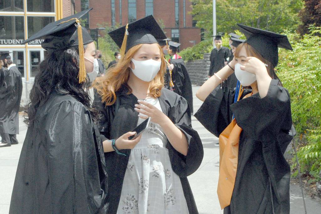 Japanese international students, from left, Malia Fujita from Yokohama, Kanagawa Prefecture, Yu Chigira, Tochigi, Tochigi Prefecture, and Haruka Nakamura, Shizuoka, Shizuoka Prefecture, prepare themselves for Saturdays associate of arts commencement ceremony at the Port Angeles campus of Peninsula College. A total of 413 students were qualified to receive degrees and certificates as part of the Class of 2020 and 2021. (Keith Thorpe/Peninsula Daily News)