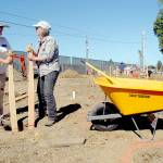 Volunteers Helga Mowry, left, and Denny Evans, both of Port Aneles, tamp down holes on Tuesday that will support componets of the future Generation II Dream Playgound being assembled by community members at Erickson Playfied in Port Angeles on the first day of a six-day build. (Keith Thorpe/Peninsula Daily News)