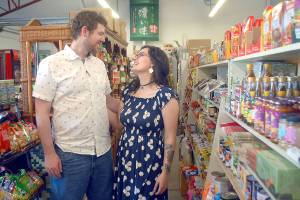 Nick and Taylor Burnette stand in the aisle of McPhees Parkway Grocery in Port Angeles, the business they recently purchased from founder Frank McPhee. (Keith Thorpe/Peninsula Daily News)