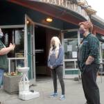 Feiro Marine Life Center Facilities Director Tamara Galvan, left, discusses admission procedures on Thursday with guest service specialists Disa Wilson, center, and Kennedy Cameron in preparation for todays reopening for walk-up visitors at Port Angeles City Pier. (Keith Thorpe/Peninsula Daily News)