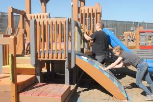 Keith Thorpe/Peninsula Daily News
Cliff Hales of Port Angeles and his daughter, Julie Hales, 14, work on a play structure at the Generation II Dream Playground at Erickson Playfield on Saturday in Port Angeles. Playground organizers held an informal build session attended by about 50 people on Saturday to make progress on portions of the playground left unfinished during last week's six-day community build. The Dream Playground Foundation will hold a two-day community build this Friday and Saturday with the hope of completing playground construction. Signups for the build can be found at padreamplayground.org.