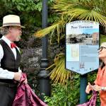 Historian Nathan Barnett of Olympic Peninsula Steam and Port Townsend Mayor Michelle Sandoval unveil a guide to the new Hidden History signs Thursday afternoon at Washington and Taylor streets. Fourteen interpretive signs, each revealing a facet of the citys past, are being posted around Uptown and downtown Port Townsend. (Diane Urbani de la Paz/Peninsula Daily News)