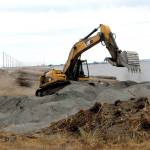 An excavator moves dirt and sand on Ediz Hook on Friday at the former site of the Olympic Peninsula Rowing Associations boat house at the edge of Port Angeles Harbor. (Keith Thorpe/Peninsula Daily News)