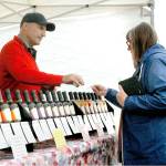 John Hershfield of Maple Valley-based Gustoblene presents a sample of lavender-flavored balsamic vinegar to Patty Reid of Bremerton at Washington Lavender east of Port Angeles. (Keith Thorpe/Peninsula Daily News)