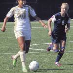 Peninsulas Dominique Niedziela, left, dribbles past Southwestern Oregons Milli Sevy iin a 2013 match in Port Angeles. The NWAC-champion 2012 and 2013 Pirate mens and womens soccer teams will be inducted into the Pirates Hall of Fame along with longtime basketball scorekeeper Bill Peterson on Sept. 25. (Keith Thorpe/Peninsula Daily News)
