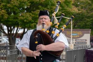 Erik Evans, the Parking Lot Piper, entertains people in downtown Sequim. (Emily Matthiessen/Olympic Peninsula News Group)