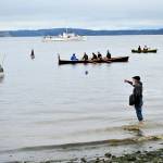 Len Feldman sends flowers to Port Townsend Bay in honor of Brion Toss, the famed rigger, teacher and author who died in June 2020. The smallest boat on the water, a one-fifth scale model of a 1933 Sam Crocker-designed catboat named Katy, was launched during the procession Wednesday morning; it bears Toss ashes. (Diane Urbani de la Paz/Peninsula Daily News)