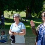 Key City Public Theatre executive artistic director Denise Winter, left, with Tobi McEnerney and her son Argus, 9, watch the youth theater workshop students perform at Chetzemoka Park on Friday. (Diane Urbani de la Paz/Peninsula Daily News)