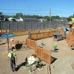 Volunteers assemble a fence around the play area of the Generation II Dream Playground at Erickson Playfield on Sunday. (Keith Thorpe/Peninsula Daily News)