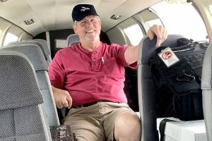 Retired pilot Josh Crabtree of Port Angeles sits in a Dash Air Shuttle Cessna 402c that he helped fly from the East Coast in June. The plane would be used for passenger flights from Fairchild International Airport in Port Angeles to Sea-Tac International Airport. (Paul Gottlieb/Peninsula Daily News)
