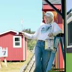 In preparation for an open house Saturday, volunteer Annalee McConnell spent much of Tuesday painting trim on the tiny shelters off San Juan Avenue in Port Townsend. (Diane Urbani de la Paz/Peninsula Daily News)