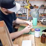 KC Mack works on a Joe Gordon wallet in his Port Angeles workshop. (Pierre LaBossiere/Peninsula Daily News)