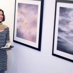 Artist Maria Coryell-Martin pauses beside two of the paintings inspired by her research on and around Alaskas Cooper Island. (Diane Urbani de la Paz/Peninsula Daily News)