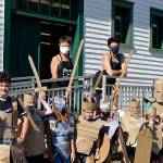 Teaching artists Margie McDonald, at left on the porch, and Michele Soderstrom led a four-afternoon course on building superhero armor for youngsters at the Northwind Art school at Fort Worden State Park in July. Their graduates are Callum Johnson, 14, Kaladry Groenig, Satria McKnight and Owen Griffith, all 11, Reid Armstrong, 10, Caleb Armstrong, 9, Byron Eisele, 8, and Nigel Groenig, 13. (Diane Urbani de la Paz/Peninsula Daily News)