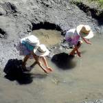 Siblings Sequoia Mitchell, 9, and Coco Mitchell, 6, both of Sequim, attempt to catch tadpoles in a side channel of the Dungeness River at Railroad Bridge Park in Sequim on Tuesday. A spell of hot weather forecast for the next several days will likely send many people on the North Olympic Peninsula seeking heat relief near the water. (Keith Thorpe/Peninsula Daily News)