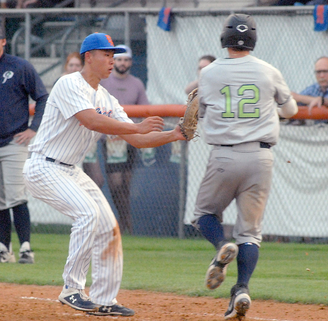 Lefties first baseman Nathan Chong, left, tags out Portlands Gabe Skoro before he can reach first in the third inning on Tuesday at Port Angeles Civic Field. (Keith Thorpe/Peninsula Daily News)
