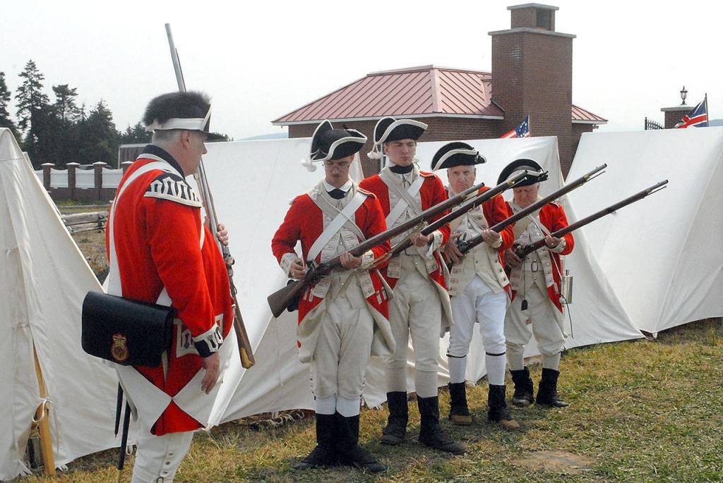 Walter Beauchamp of Sammamish, left, leads a gun drill with a group of English redcoats, from left, Morgan Baker of Lacey, Stephen Norby of Lacey, Paul Timmerman of Dover, N.H., and Bob Ballard of San Antonio, Texas, at Saturdays Northwest Colonial Festival at the George Washington Inn east of Port Angeles. The event featured displays, demonstrations and reenactments of life during the colonial era of the American Revolution. (Keith Thorpe/Peninsula Daily News)