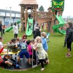 Children cavort on a merry-go-ground after Friday evenings soft opening of the Generation II Dream Playground at Erickson Playfield in Port Angeles. (Keith Thorpe/Peninsula Daily News)