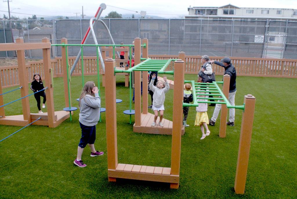 A set of climbing bars draws the attention of children on the opening day of the Dream Playground on Friday in Port Angeles. (Keith Thorpe/Peninsula Daily News)