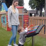Felicia Horton of Port Angeles watches as her dauighter, Ellie Baermann, 18 months, plays with a xylophone at the Dream Playground on Friday. (Keith Thorpe/Peninsula Daily News)