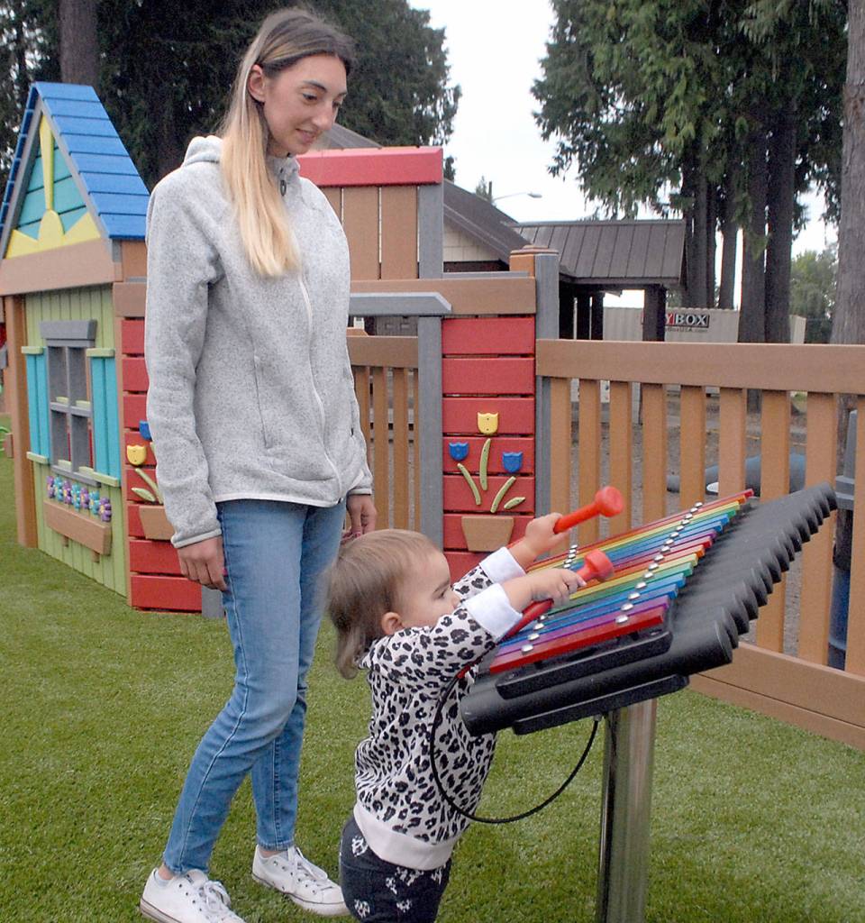 Felicia Horton of Port Angeles watches as her dauighter, Ellie Baermann, 18 months, plays with a xylophone at the Dream Playground on Friday. (Keith Thorpe/Peninsula Daily News)