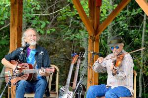 John Greyhound Maxwell, left, and Jon Parry dish up blues and swing Saturday afternoon outside the Laurel B. Johnson Community Center in Coyle. Their show was likely to be the last of the seasons Concerts in the Woods series. (Diane Urbani de la Paz/Peninsula Daily News)