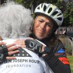 Special education kindergarten teacher Amy DelaBarre of Port Angeles gives an emotional hug to Betsy Schulz, founder of the Captain Joseph House Foundation in Port Angeles, after DelaBarre completes the bicycle portion of Run for Joe, a solo triathlon on Saturday to raise funds in support of Gold Star families who have lost loved ones in military action. The Captain Joseph House, a former bed and breakfast, which was converted to give respite to military families, is named for Schultzs son, Joseph Schultz, who was killed in action in Afghanistan on May 29, 2011. (Keith Thorpe/Peninsula Daily News)