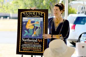 Northwind Art Executive Director Teresa Verraes shows off the just-finished collective painting at the close of The Big Reveal, the fundraiser held at Fort Worden State Park on Sunday. (Diane Urbani de la Paz/Peninsula Daily News)